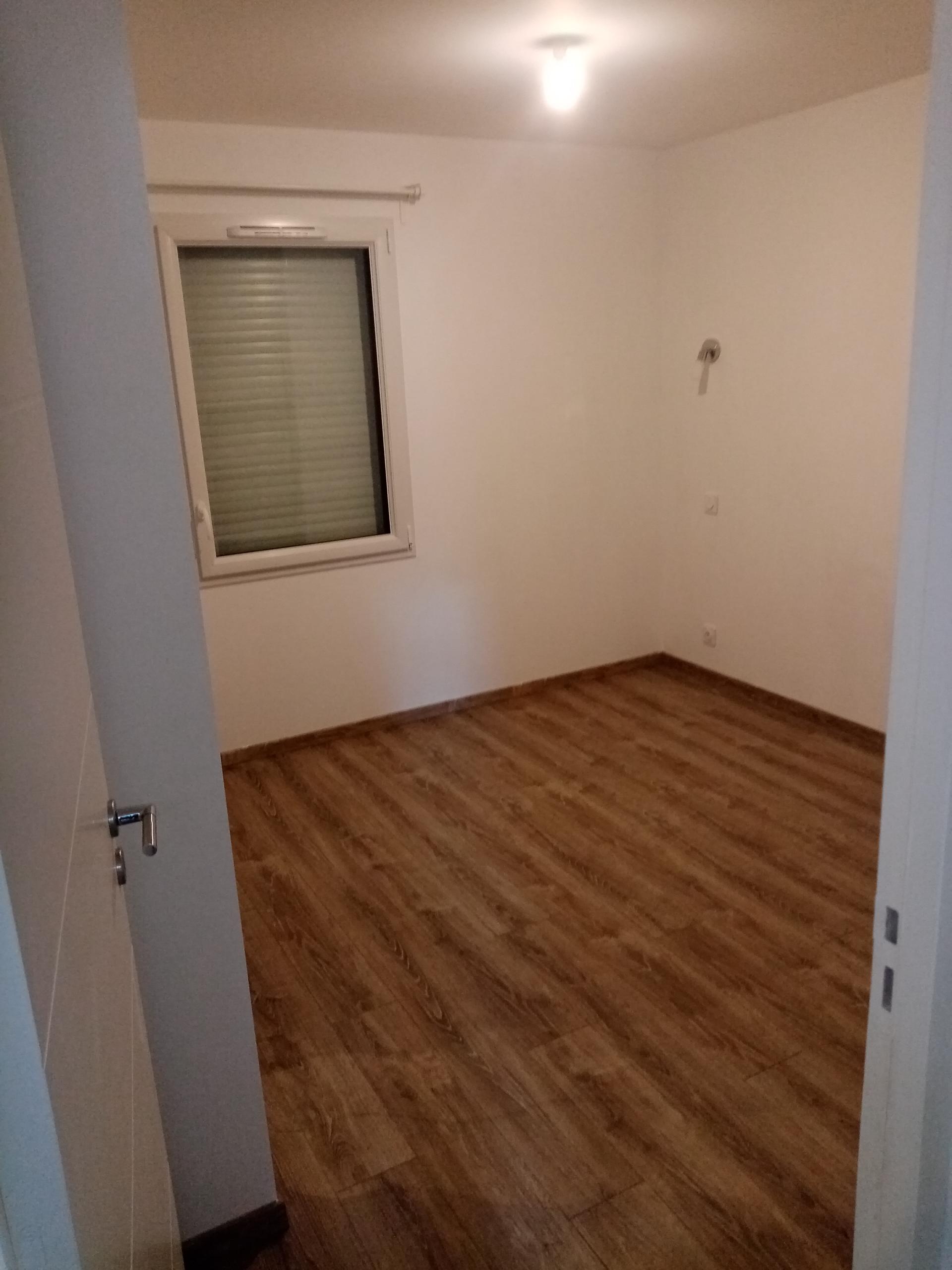 Chambre remise à neuf — parquet stratifié lavé, plinthes reprises
