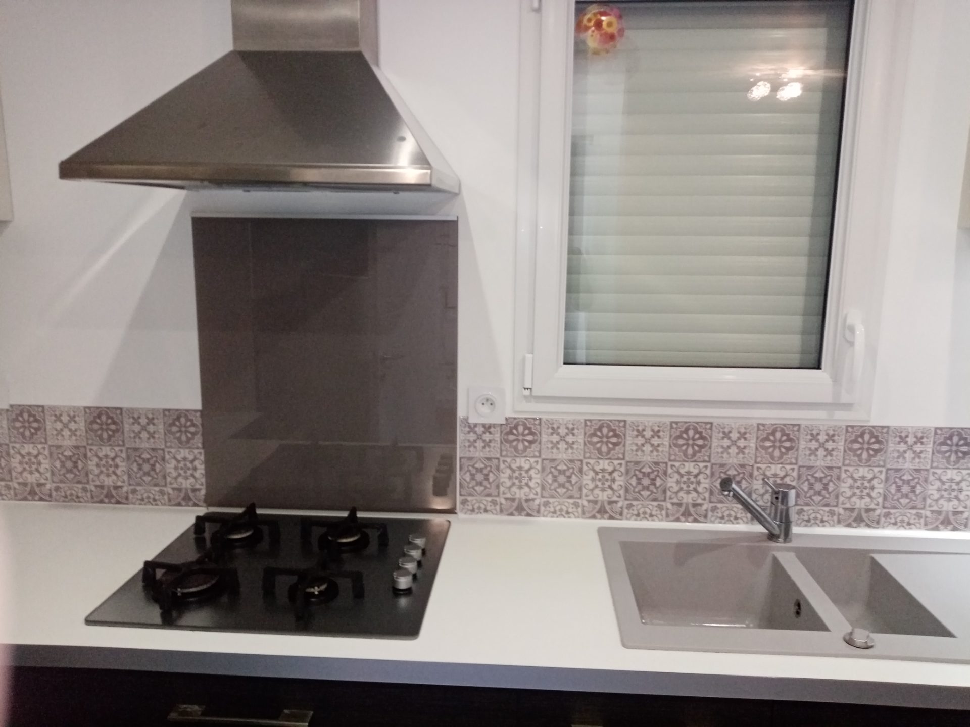 Cuisine — plaque de gaz, crédence carreaux de ciment, inox de la hotte dégraissé